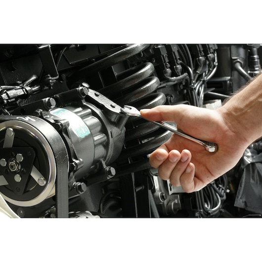 Facom 440_1_2 combination wrench used to tighten bolt on engine component.