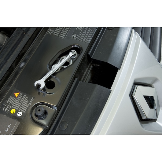 Facom 440.13/16 combination wrench on black car engine component, partial view of silver car with logo.