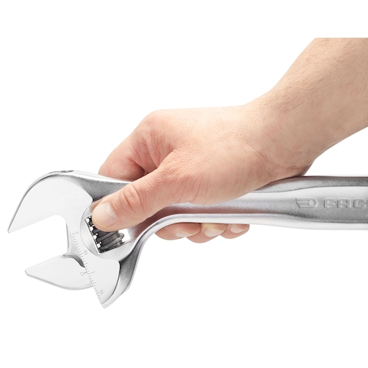 Photo of a hand holding a Facom adjustable wrench, 101_8, silver finish, close-up on white background.