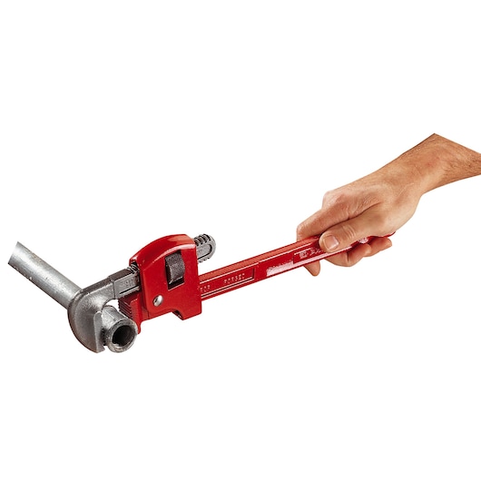 Photo of Facom 134A_10 red pipe wrench in use, gripping a metal pipe, side angle.