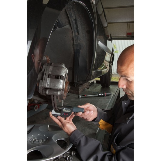Facom 1355A electronic caliper measuring car brake disc thickness during maintenance.