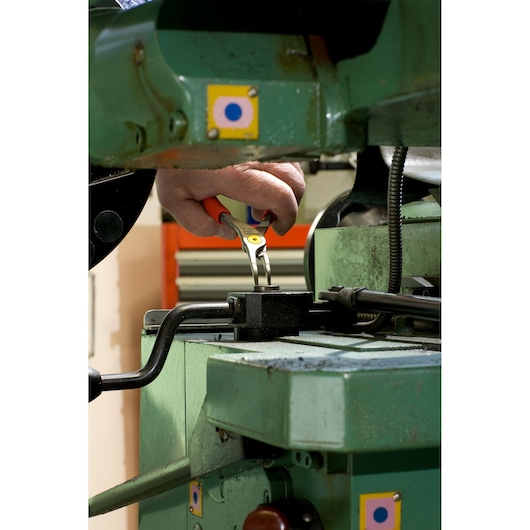Photo of Facom 167A23 pliers used on industrial machine, close-up showing tool in action.