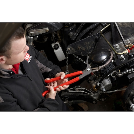 Facom 170.FILPB oil filter pliers with red handles used to loosen an oil filter on machinery.