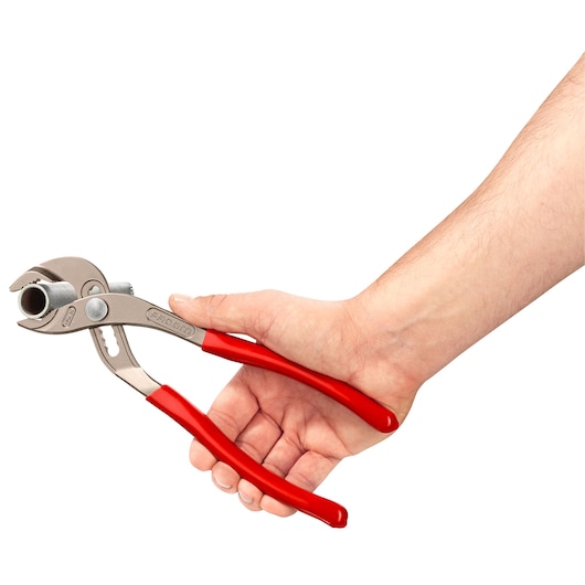 Photo of Facom 170A_25 slip joint pliers with red handles held in a hand, white background, side angle.