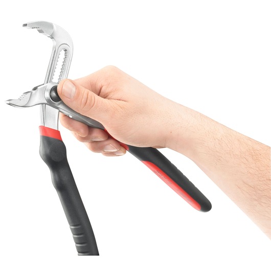 A hand holding adjustable pliers with black and red handles, isolated on a white background.
