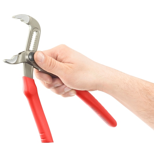 A hand holding adjustable pliers with red handles against a white background.