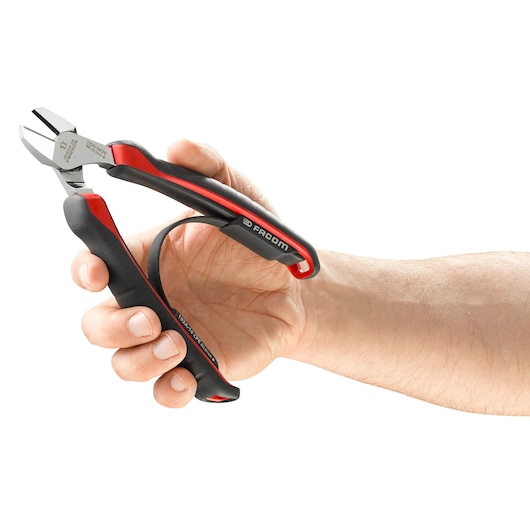 Photo of Facom 192A16CPE ergonomic diagonal cutter with black and red handles held in a hand, side angle.