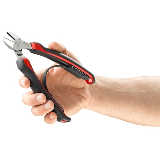 Photo of Facom 192A_18CPE diagonal cutter pliers with black and red handles held in a hand, side angle.