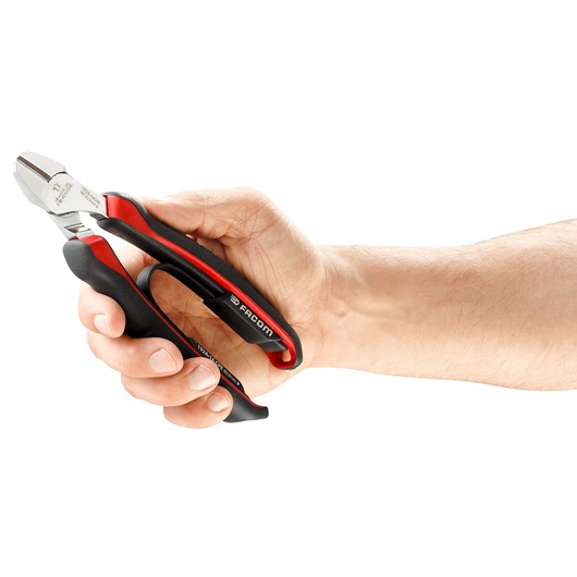 Facom 192A_18CPE diagonal cutting pliers with black and red handles held in a hand, side angle.