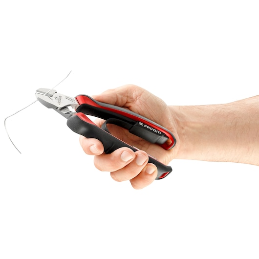 Photo of Facom 192A_18CPE diagonal cutting pliers with black and red grip cutting wire, held in a hand.