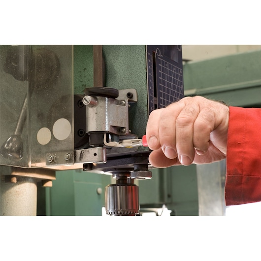 Facom 197A_18 photography of hand using red-handled tool on industrial machine.