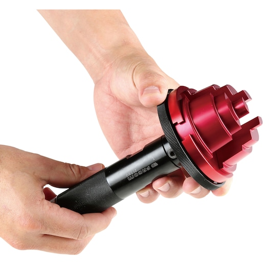 Photo of Facom 21790 tool with red multi-tiered attachment, shown in hands, close-up on white background.