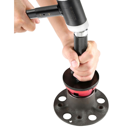 Photo of Facom tool 217.J2PB being used to prepare a pipe flange, close-up showing hand operation.