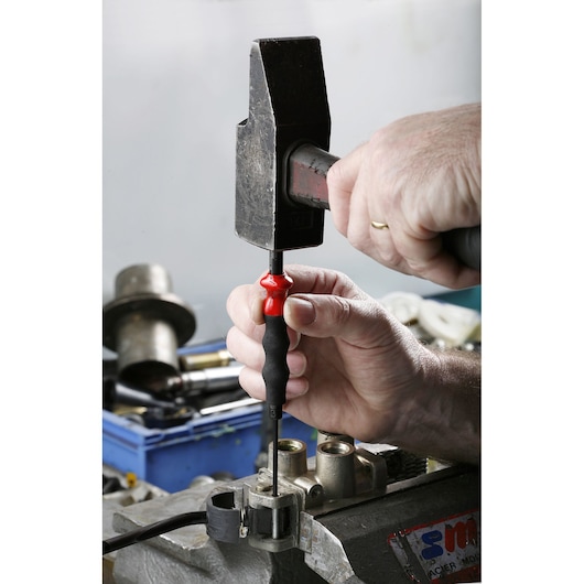 Photo of Facom 249_G3 screwdriver being hit with a hammer for workshop use, black and red handle, close-up.