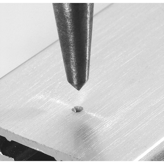 Facom 257_G steel punch marking a hole on a metallic surface, close-up photo, photography category.