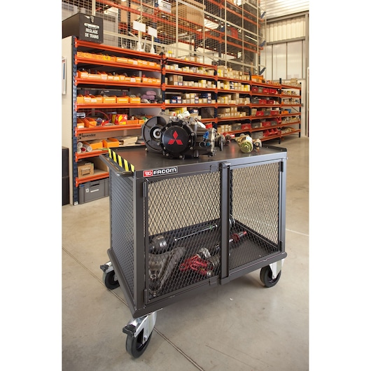 Facom 2703 metal mesh utility cart with locking doors on casters, workshop background, angled view.