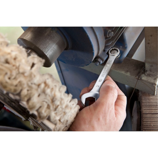 Photo of Facom 39_14 combination wrench being used to tighten a bolt on industrial machinery.