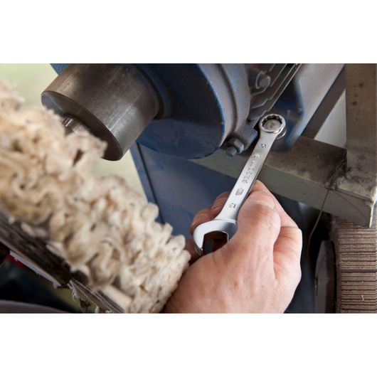 Photo of Facom 39_15 open-end wrench being used to tighten bolt on industrial machine.