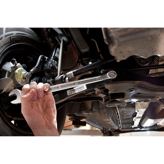 Photo of Facom 40_24LA wrench being used on a car’s underside, mechanics hand holding the tool.