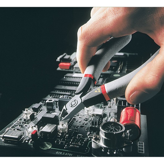 Facom 405_E diagonal cutter being used on an electronic circuit board, close-up view.