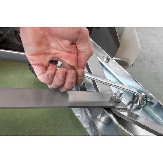 Facom 41_8 wrench in hand tightening bolt on metal frame, close-up photography.