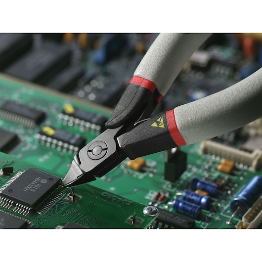 Facom 417_SPE precision side cutters with grey and red handles cutting wires on a green circuit board.