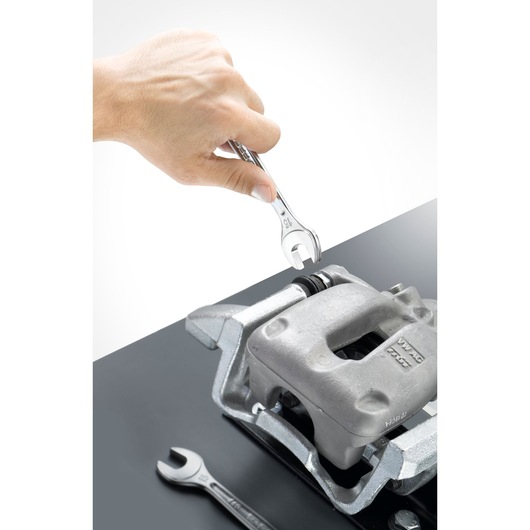 Facom 440_29 open-end wrench used on a metal automotive part, top angle, second wrench nearby.