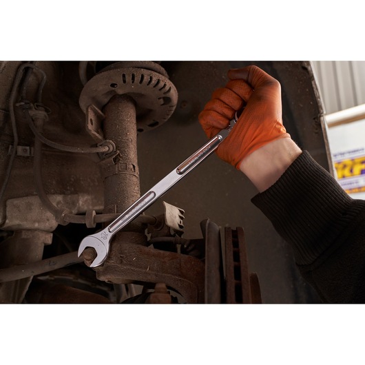 Facom 440XL_19 open-end wrench used on car suspension by gloved hand, automotive tool photography.