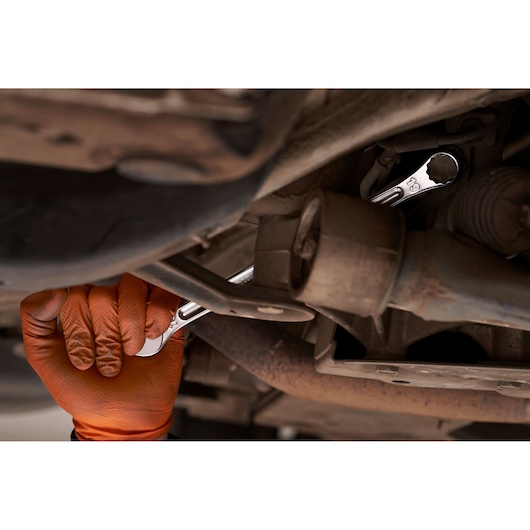 Photo of Facom 440XL_19 wrench in use on a car engine, hand with orange glove gripping the tool.
