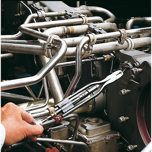 Facom 445_8R pliers photography showing tool adjusting metal pipes in industrial machinery.