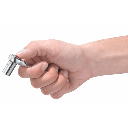 Photo of a hand holding a Facom 467ADAPT10MM compact ratchet socket, silver finish, side angle.