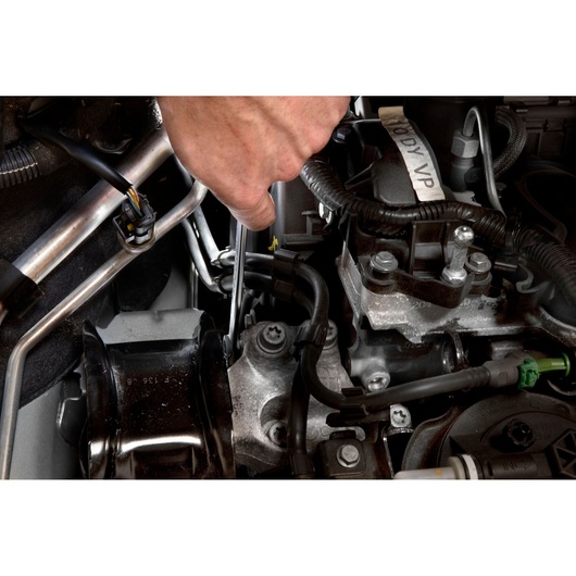 Facom 59_22X24 wrench being used to tighten a bolt in a car engine compartment.