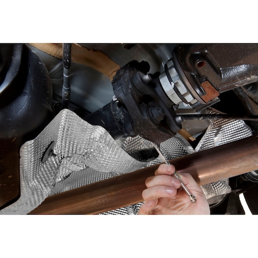 Facom 59TX_14X18 double-ended wrench used to tighten a bolt on an automotive drivetrain undercarriage.