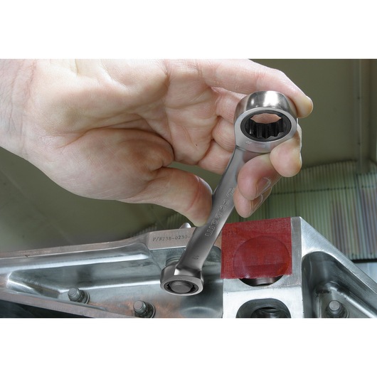 Photo of a hand using a Facom ratcheting box wrench, SKU 64_3_4X13_16, on a metallic assembly part.