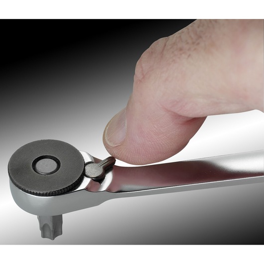 Photo of a hand operating the switch on a Facom 65PE ratchet wrench, close-up view.