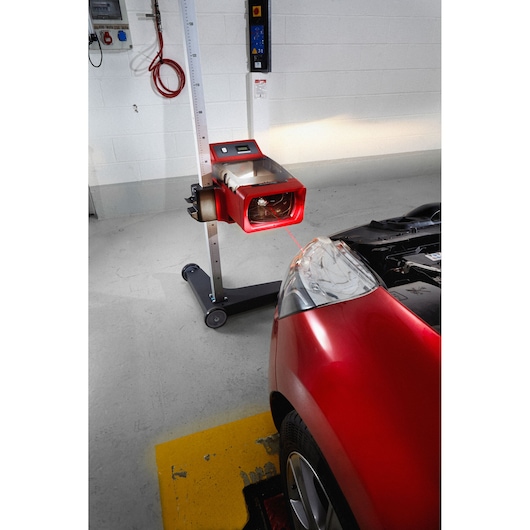 Facom 740A headlamp beam tester in use aligning a car headlight in a garage.