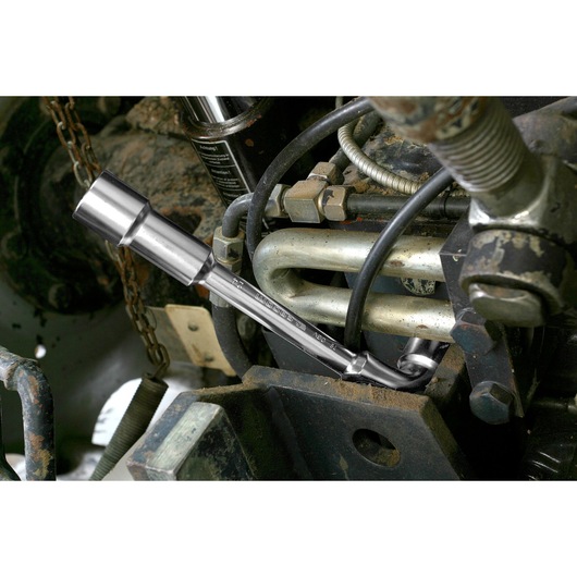 Facom 75_24 chrome socket wrench in use on machinery part, close-up photography.