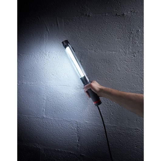 Facom 777B230F handheld LED work light illuminating a concrete wall, photography scene.