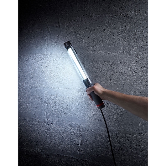 Facom 777B24F handheld LED work light illuminating a gray textured wall.