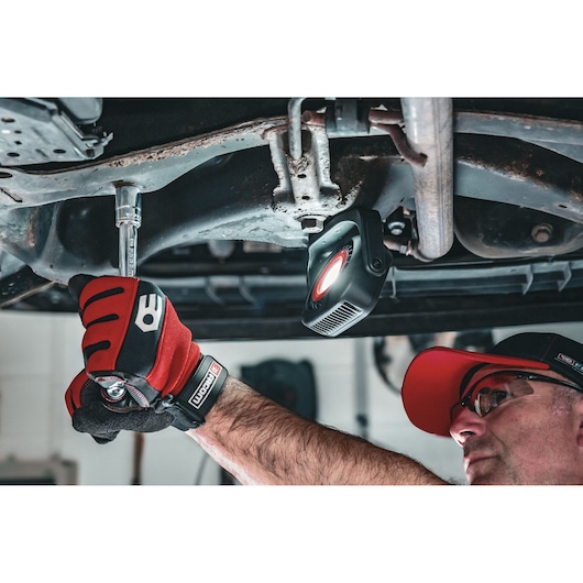 Facom 779.1000BLPB mechanic work light illuminating under car, person using wrench with Facom gloves.