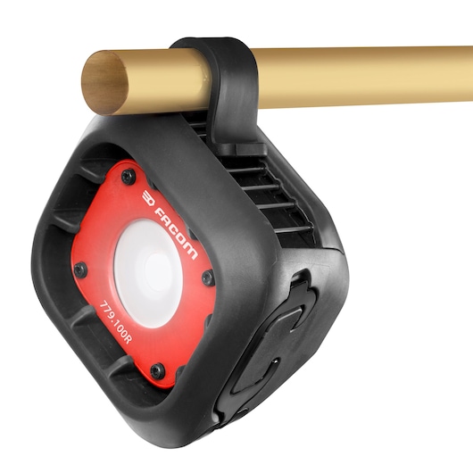 Photo of Facom 779.1000RPB work light with red and black body, hanging from a yellow rod, front angle.