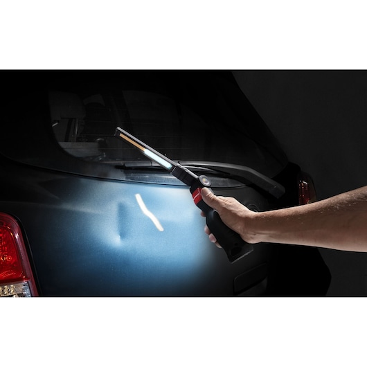 Facom 779CML inspection lamp used for lighting car rear panel, handheld in automotive context.