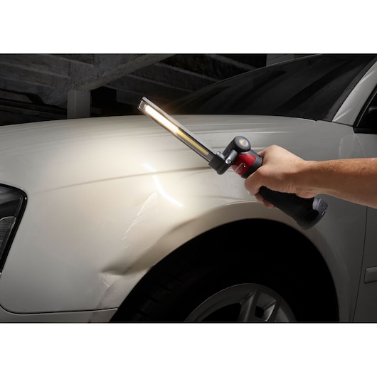 Facom 779CML inspection lamp illuminating car body, photography showing light beam and ergonomic handle.