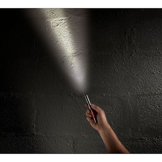 Facom 779_PBT pen light in hand, beam illuminating a dark textured wall.