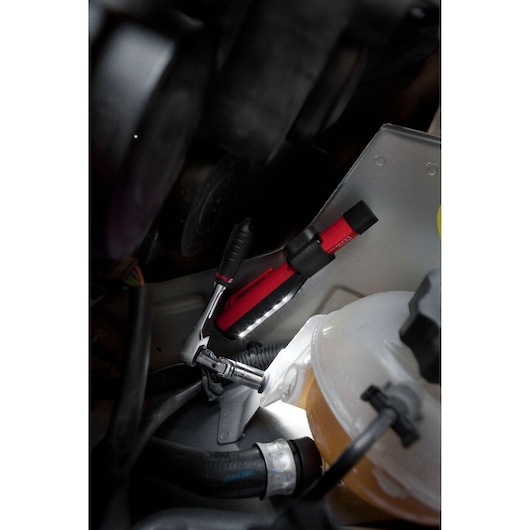 Facom 779.PENPB red LED inspection lamp and ratchet tool in automotive engine bay.