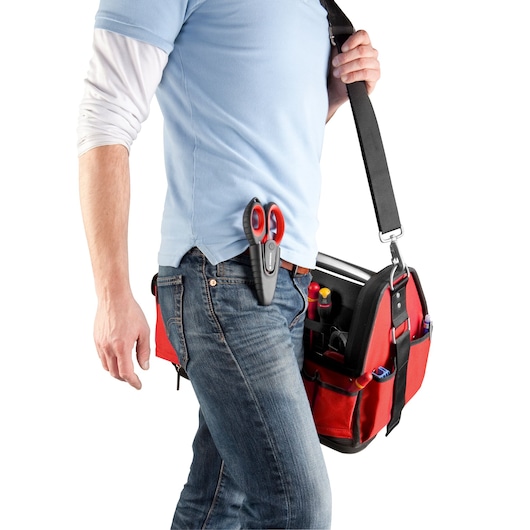 Photo of person carrying Facom red tool bag 841A.3PB with scissors clipped to jeans and tools visible in pockets.