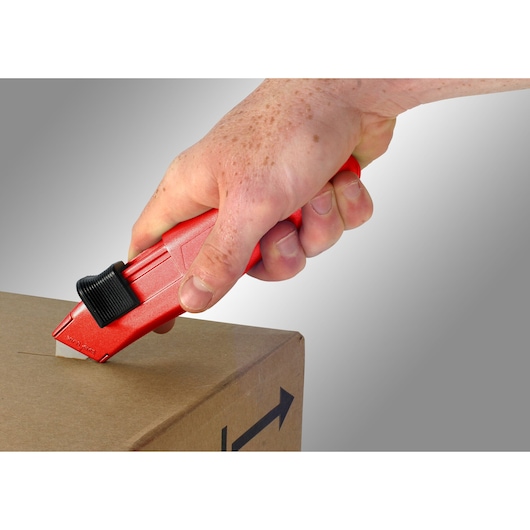 Facom 844_D red safety box cutter used to open cardboard box, close-up photography.