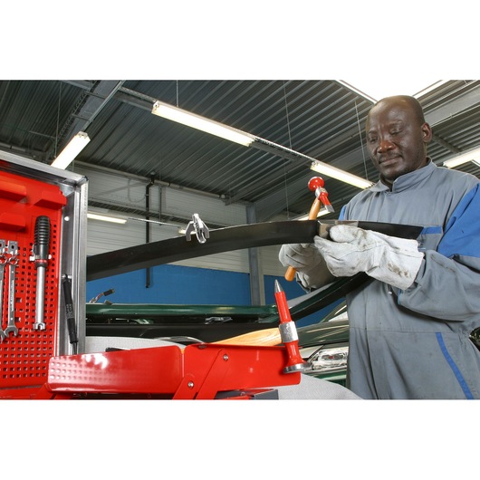 Facom 868D_40PLD1 auto body repair tools in red case with technician shaping metal part in workshop.