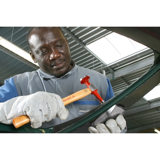 Facom 868D_40PLD1 red-headed hammer with wooden handle used by worker wearing gloves.