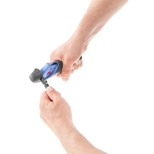 Photo of hands using Facom 872271 pipe cutter on a black hose, close-up, white background.